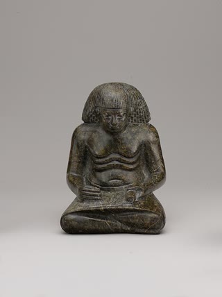 Statuette of a scribe, ca. 1427–1347 BCE: seated, papyrus unrolled across the kilt — the posture that administered a civilization. Metropolitan Museum of Art, Open Access (CC0).