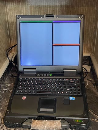 TitaniumWM in production use — split panes, tab bar, xterm — on the B300's own screen. Photograph by Rocky L. Oliver.