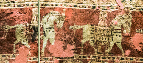 Horsemen on a Pazyryk felt carpet — from the frozen burial mounds of the Altai, where permafrost preserved wool, wood, and tattooed skin for 2,500 years (Ninara, CC BY-SA 4.0).