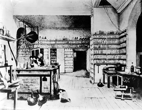 Faraday at work in his laboratory at the Royal Institution — the bookbinder's apprentice whose hands built the electrical age (Wellcome Collection, CC BY 4.0).