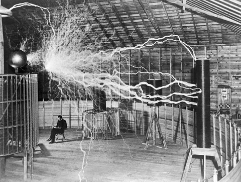 Nikola Tesla reading beneath the streamers of his magnifying transmitter, Colorado Springs, 1899 — a double exposure staged for maximum theater, and still the most Tesla photograph ever taken (Dickenson V. Alley, public domain).