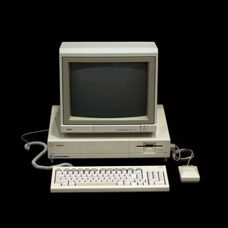 The Commodore Amiga 1000 — the 1985 machine whose multitasking OS kernel Sassenrath wrote. REBOL's obsession with small, messaging, cooperating systems is Amiga thinking carried to the network (Rama & Musée Bolo, CC BY-SA 2.0 FR, via Wikimedia Commons).